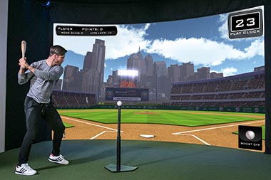 Player hitting baseball at screen of sport simulator